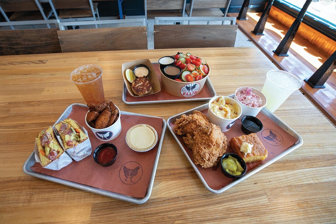 Three Ellis' trays — fried chicken plate, spicy tuna roll, salad — gathered together