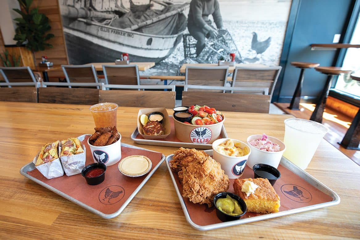 Wide view of the dining room — the historic Ellis Parker bayman mural in the background, three trays of food in the foreground
